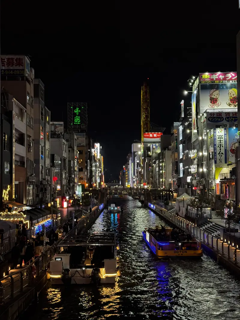 El canal de Dotonbori de noche con los letreros de neón reflejados en el agua