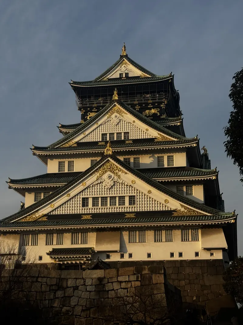 El castillo de Osaka con sus tejados verdes y detalles dorados bajo un cielo despejado