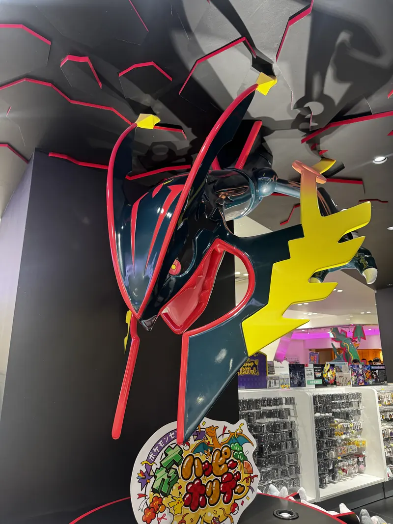 Una figura oscura de un Pokémon dragón con detalles rojos y amarillos