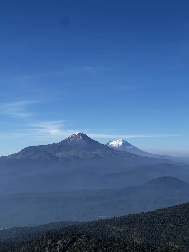 Los volcanes vistos desde un claro, entre capas de montañas azuladas