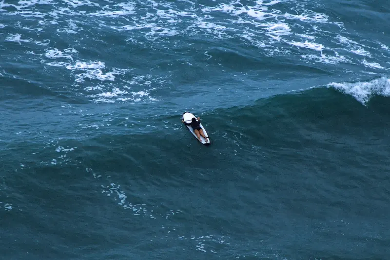 Un surfista solo sobre su tabla en mar abierto
